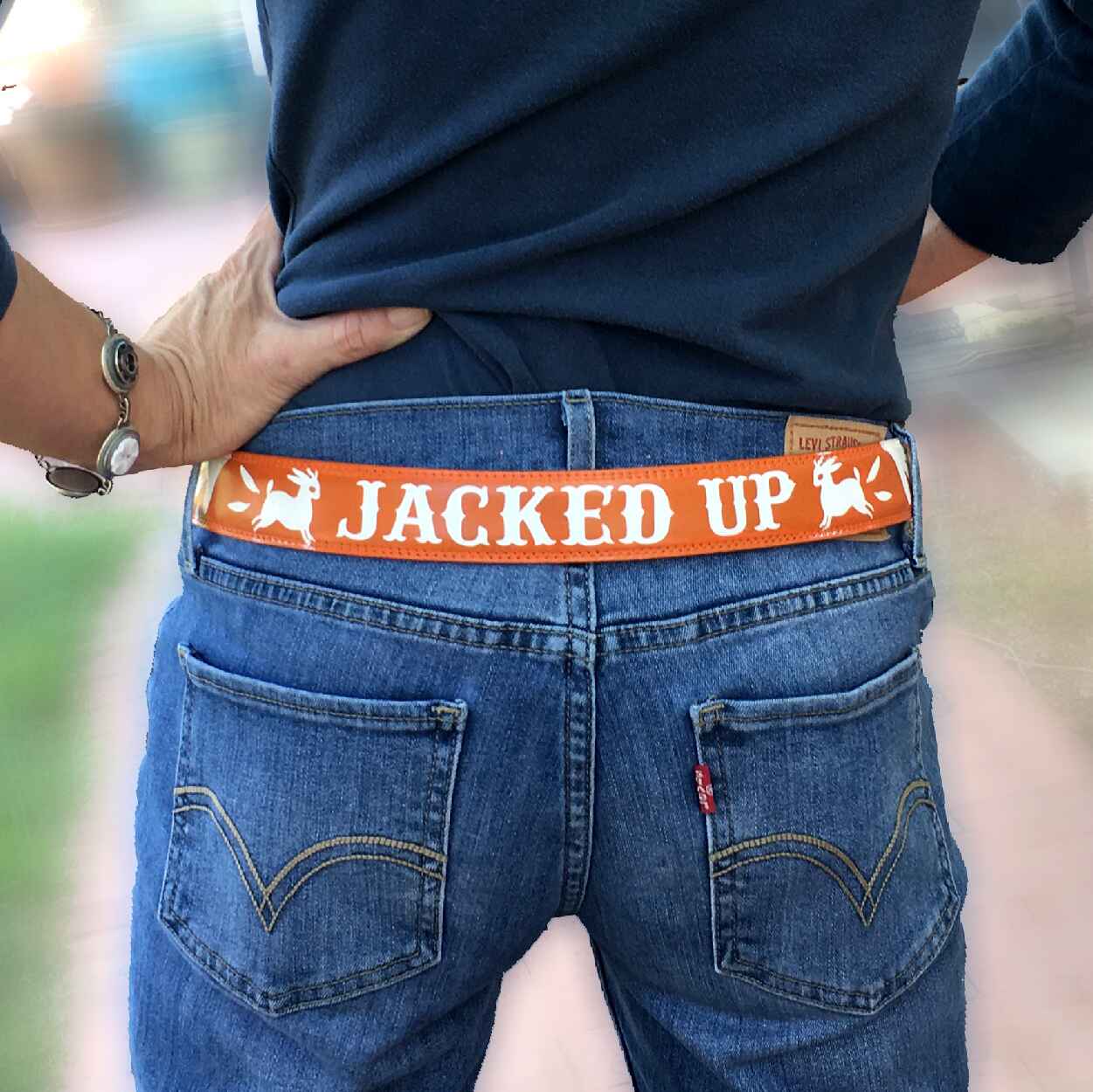 Man wearing a belt with a jackalope design on the belt and text saying Jacked Up