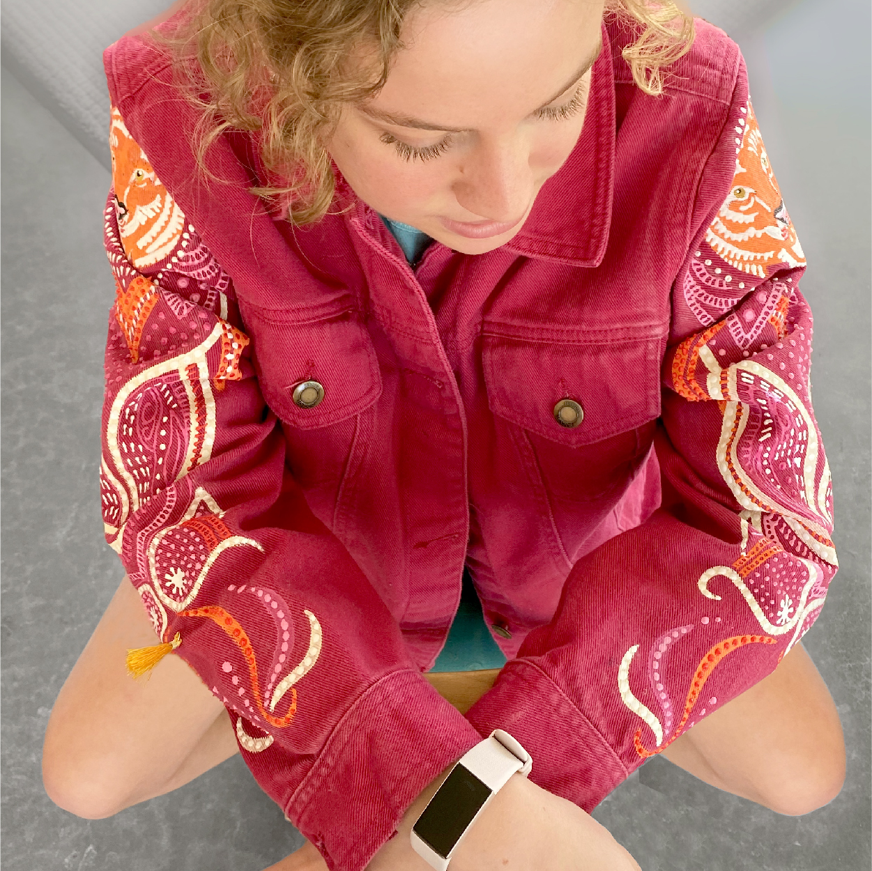  red denim jacket with a bright orange painting on the arms. 